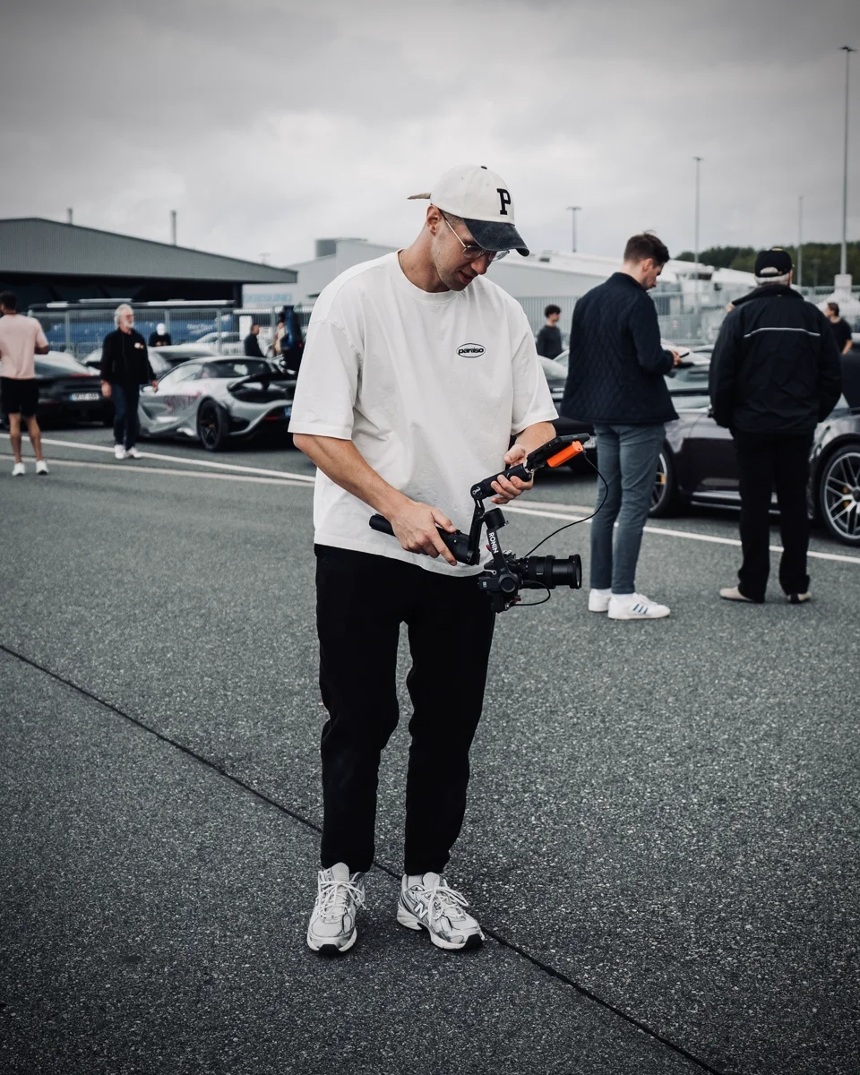 Henrik mit Kamera und Gimbal bei einem Dreh auf einem Auto-Event